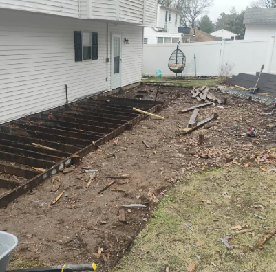 Backyard deck demolished down to framing with debris cleared from the yard