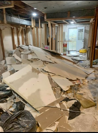 Commercial space with drywall torn out and stacked in piles ready for disposal