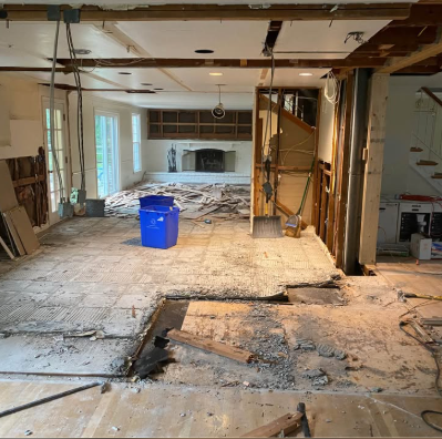 Main floor opened up with walls removed and subfloor exposed during an open-concept renovation demolition