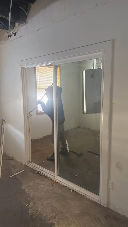 Crew member working behind a glass sliding door in an office being stripped out