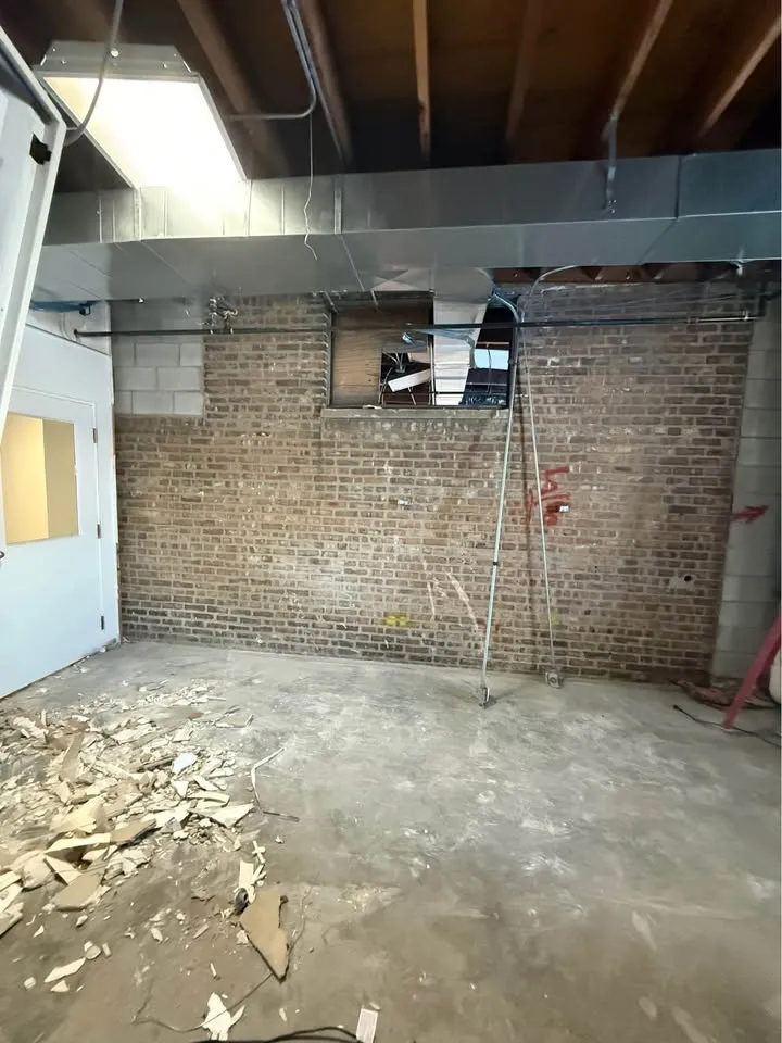 Commercial room stripped back to bare brick with ductwork overhead