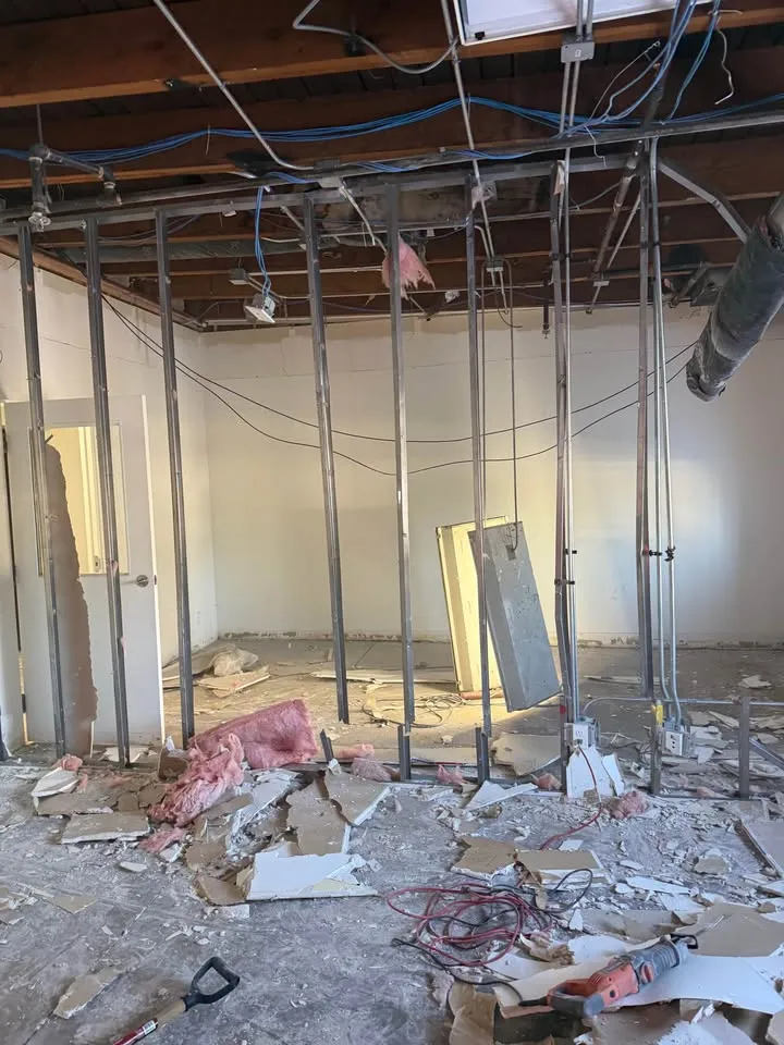 Commercial room reduced to its steel stud frame with debris on the floor