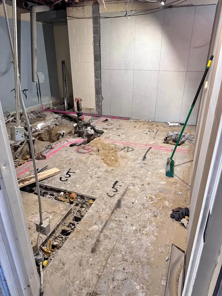 Basement floor saw-cut in a trench pattern with markings on the slab