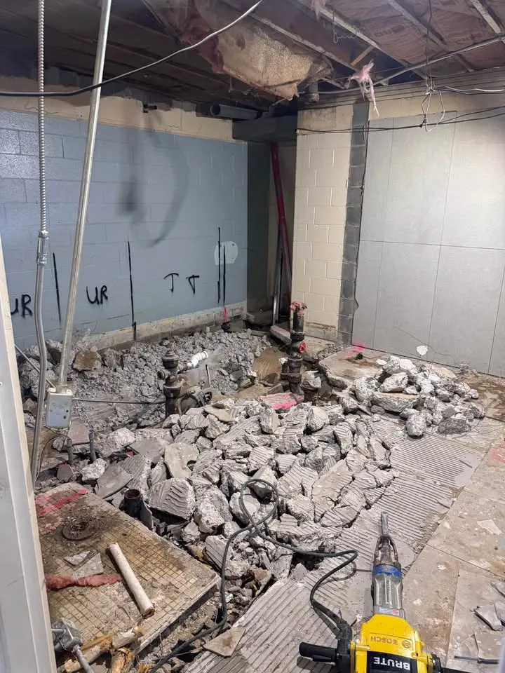 Basement slab broken into rubble between marked block walls