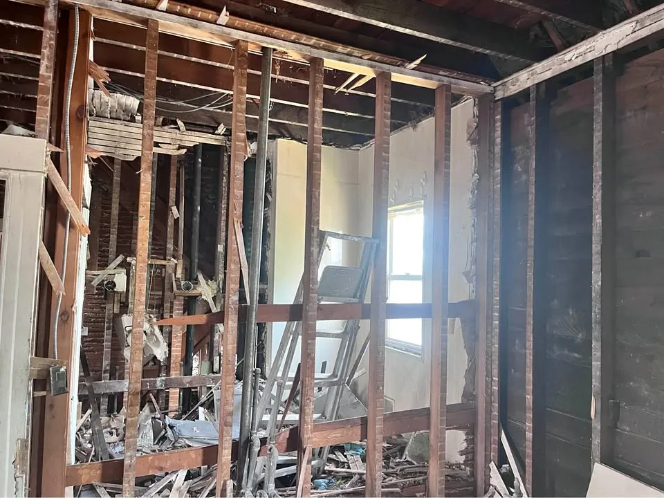 Interior stripped to charred studs and joists with the exterior wall exposed