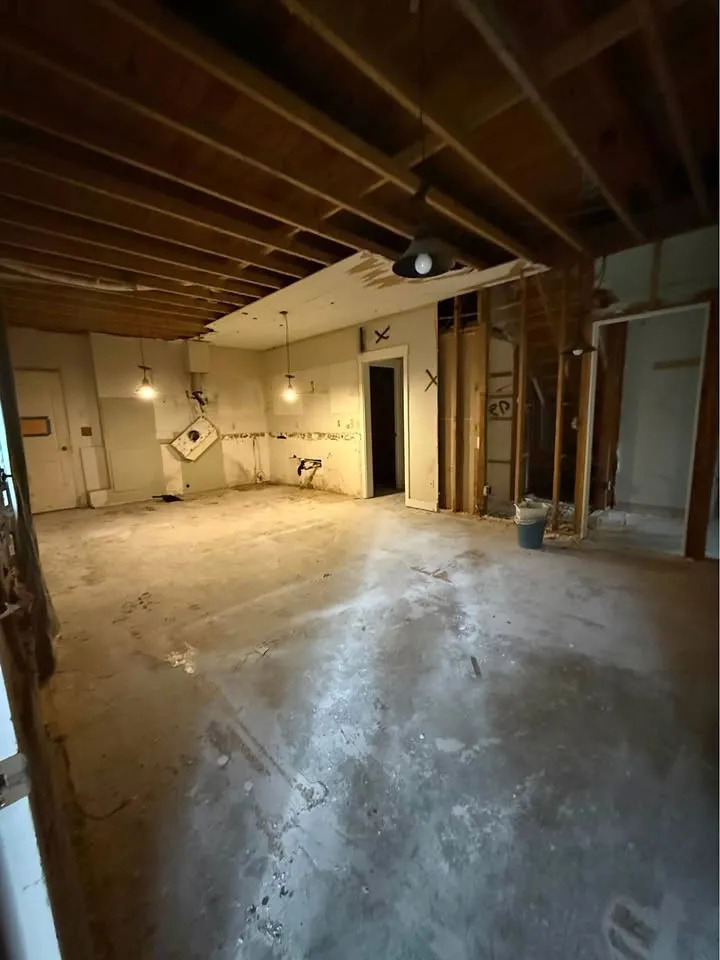 Kitchen cleared of cabinets and fixtures with the concrete floor swept