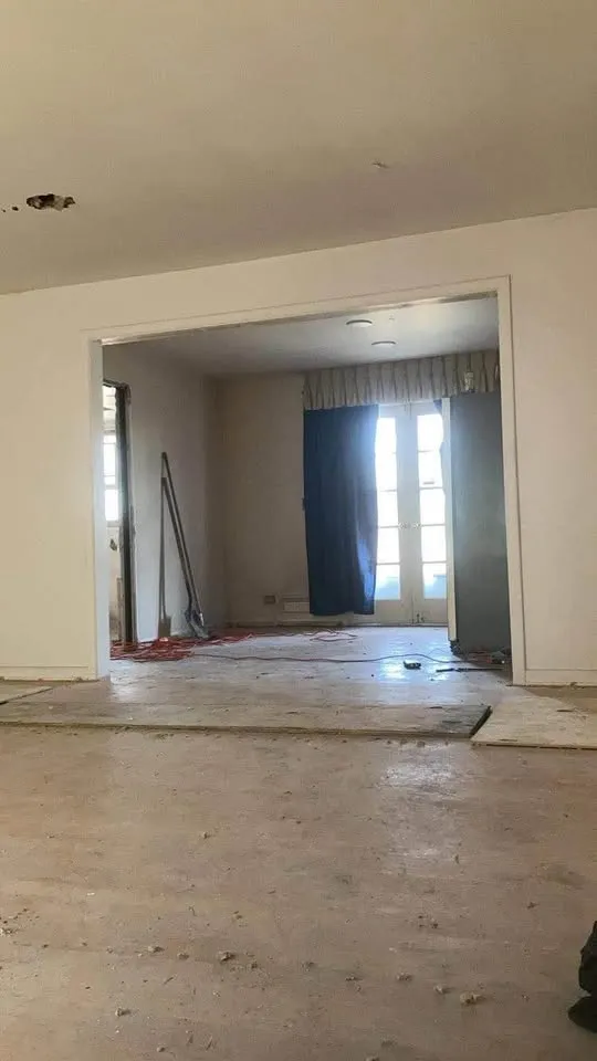 Room with flooring lifted and walls ready for the next stage of demolition