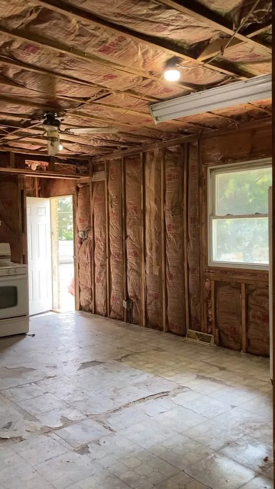 Kitchen stripped to studs and foil-faced insulation with the stove still in place