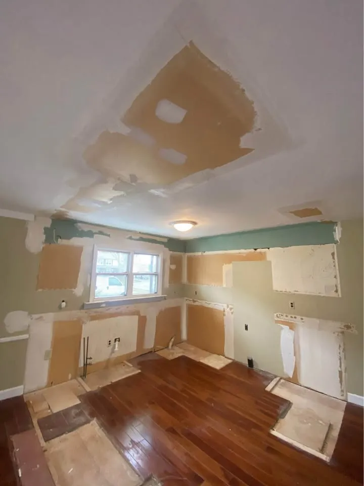 Empty kitchen with patched ceiling and cabinet outlines left on the walls
