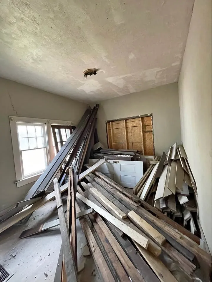 Small room stacked with torn-out trim, lumber and old doors