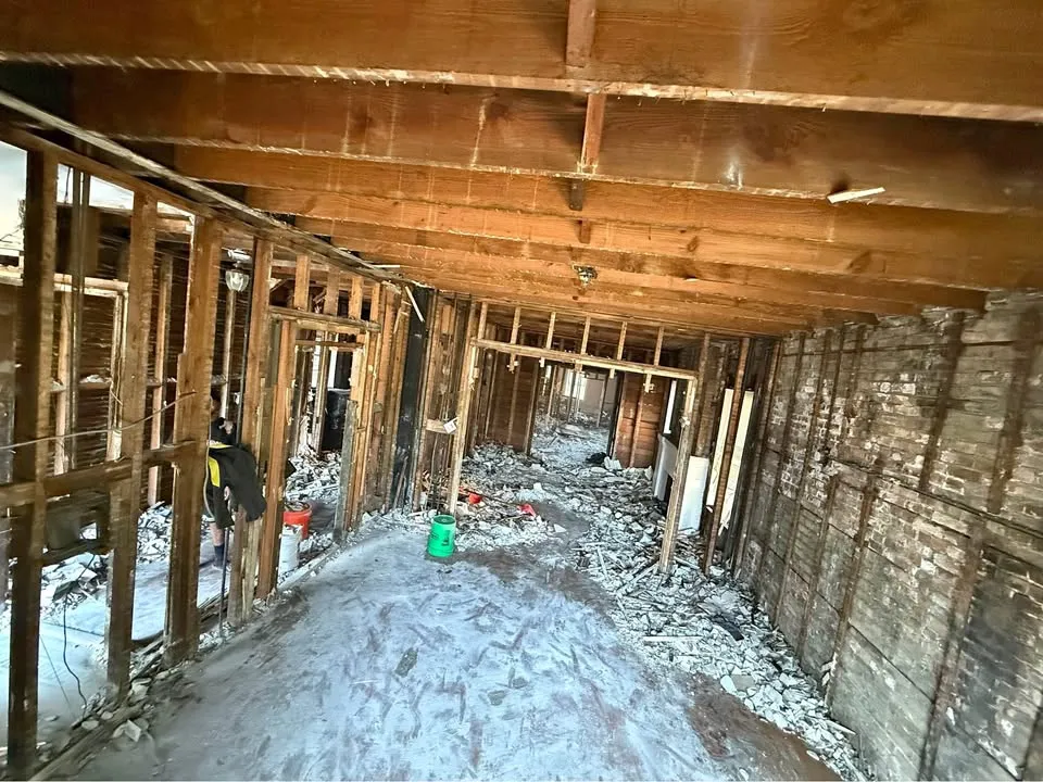 Long interior gutted to the framing and brick with debris along the floor