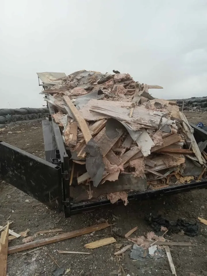 Dump trailer loaded with demolition lumber and drywall