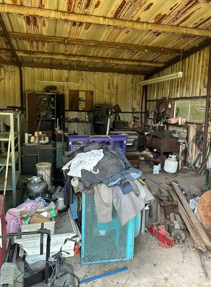 Crowded workshop shed full of old tools and materials before clearing