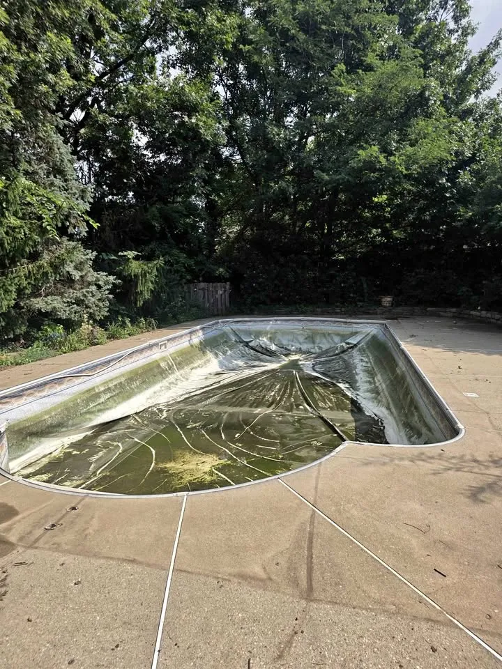 Inground pool with its cover still on before removal begins